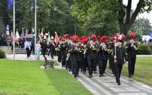 Orkiestra KWK Knurów z muzycznym akompaniamentem wprowadza poczty sztandarowe wraz z gośćmi na plac przed pomnikiem Św. Barbary