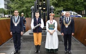 Prezydent Miasta i Przewodniczący Rady Miasta wraz z młodzieżą w strojach regionalnych dokonują uroczystego wmurowania kapsuły czasu